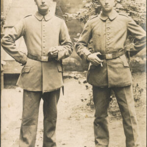 dwóch żołnierzy w mundurach z papierosami; w tle zabudowania