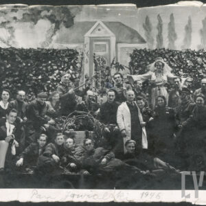 większa grupa osób ustawionych w różnych pozach na scenie; wkoło scenografia