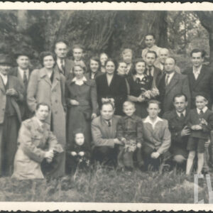 większa grupa ludzi, kobiet, mężczyzn i dzieci, pozująca na tle dużego drzewa