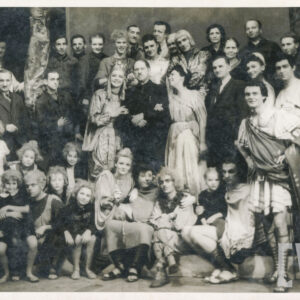 większa grupa ludzi w kostiumach stojących i siedzących