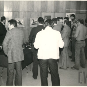 ludzie oglądający fotografie powieszone na ścianie