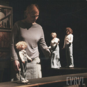 trzy lalki ze spektaklu, za nimi aktorka animująca lalki