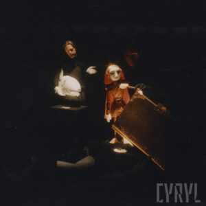 na pierwszym planie oświetlone dwie lalki, w głębi dwaj animujący je aktorzy