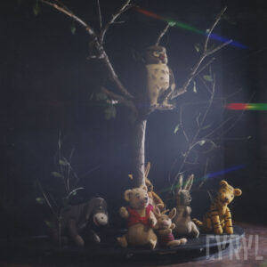 scenografia złożona z drzewka i wokoło niego umieszczonych lalek ze spektaklu, na drzewie lalka sowy