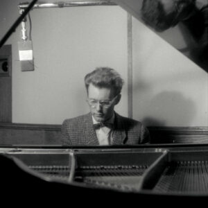 młody mężczyzna siedzący przy fortepianie w studio nagraniowym