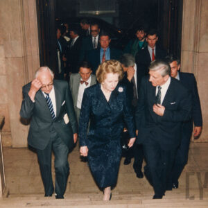 starsza elegancko ubrana kobieta wchodząca po schodach w towarzystwie starszych, elegancko ubranych mężczyzn 