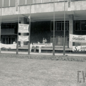 transparenty z hasłami przed budynkiem