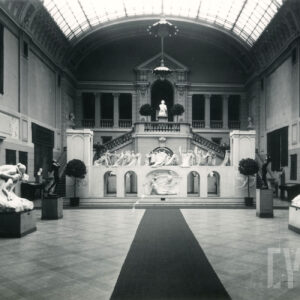 duży hol z monumentalnymi schodami, wysokim przeszklonym sklepieniem i rzeźbami ustawionymi na sali i balkonach