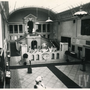 duży hol z monumentalnymi schodami, wysokim przeszklonym sklepieniem i rzeźbami ustawionymi na sali i balkonach