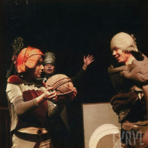 trzy osoby w kostiumach, kobieta z lewej trzyma w rękach duży kłębek wełny lub sznurka