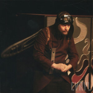 mężczyzna w kostiumie, ze skrzydłami na plecach oraz pilotce na głowie i goglach