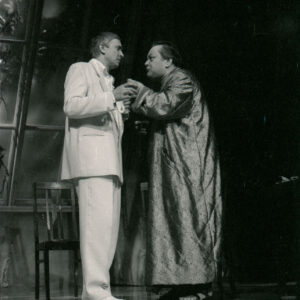 dwóch mężczyzn zwróconych do siebie twarzami stoi na scenie