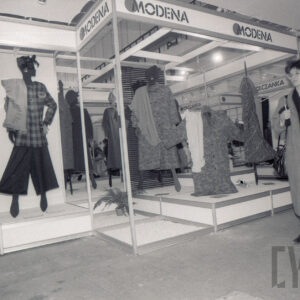 hala ze stoiskami z manekinami, na których prezentowana jest odzież, z prawej idzie kobieta