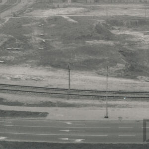 szeroka ulica widoczna z lotu ptaka, wzdłuż niej biegną tory tramwajowe, dalej nieużytki