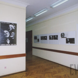 wnętrze salonu wystawienniczego, na ścianach wiszą fotografie różnego formatu, na podłodze parkiet