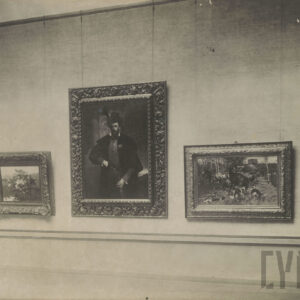 kilka obrazów podwieszonych na linkach, przedstawiających postacie ludzkie i scenki rodzajowe