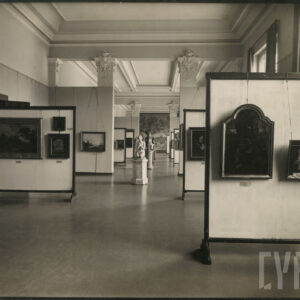 przestronna sala z wysokimi kolumnami, ozdobnymi stropami oraz z licznymi posągami na postumentach; na ściankach ekspozycyjnych obrazy podwieszone na linkach