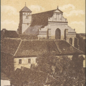 na pierwszym planie trzykondygnacyjny budynek w formie czworoboku ze spadzistym dachem, za nim budynek sakralny z przylegającą do niego wieżą