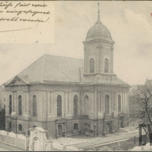 budynek sakralny ze spadzistym dachem z przylegającą do niego pośrodku wieżą, otoczony murowanym ogrodzeniem z okazałą bramą