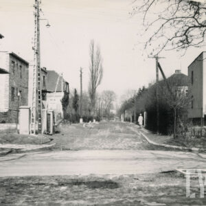 częściowo rozkopana, brukowana ulica, przy której trwa budowa domów jednorodzinnych