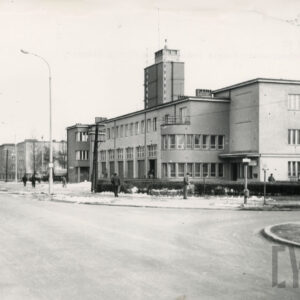 rozczłonkowany, urozmaicony architektonicznie budynek z wieżą stojący przy skrzyżowaniu pustych ulic