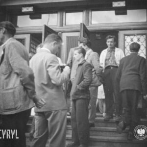 grupa ludzi przed wejściem do budynku