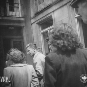 grupa ludzi przed drzwiami do budynku