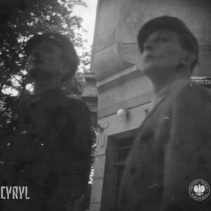 dwóch mężczyzn spogląda w górę, za nimi fragment kamienicy