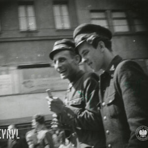 dwóch mężczyzn w mundurach, w głębi fragment budynku