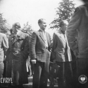 kilku mężczyzn, część w płaszczach, część w marynarkach