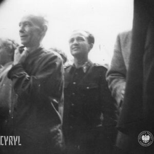 kilku mężczyzn, pośrodku mężczyzna w mundurze