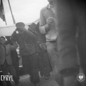 grupa ludzi idzie ulicą, kilku mężczyzn niesie coś ponad głowami