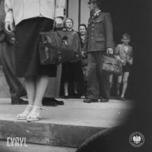 kilka osób wychodzi z budynku, jeden z mężczyzn w mundurze z teczką w ręce