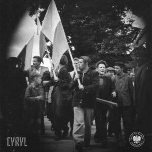duża grupa przeważnie młodych mężczyzn, kilku z nich trzyma w rękach polskie flagi na drzewach, w głębi drzewa