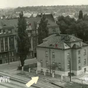ogrodzona willa miejska z lotu ptaka na narożniku ulic, po drugiej stronie ulicy duża kamienica