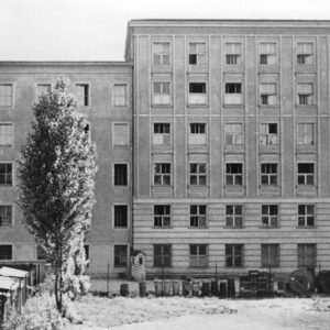 kilkupiętrowy budynek, w kilkunastu oknach powybijane szyby