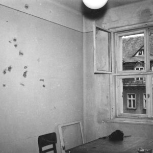 pomieszczenie biurowe z meblami biurowymi, na ścianach ślady po ostrzale