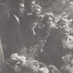 duża grupa ludzi, na pierwszym planie wiązanka kwiatów