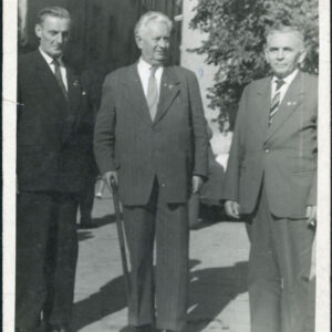 trzech starszych mężczyzn w garniturach pozujących do zdjęcia