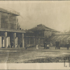 rozczłonkowana budowla ze szklanymi ścianami i dachem, przed budowlą kilkoro ludzi