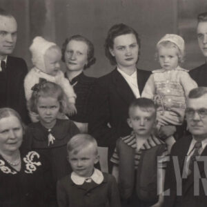 grupa elegancko ubranych osób w różnym wieku, pozująca do fotografii