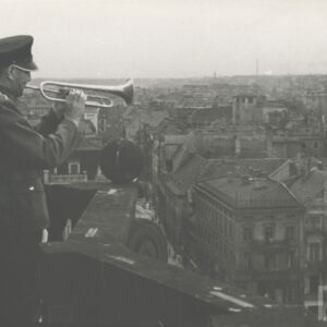 Hejnalista na wieży ratusza, poniżej fragment południowej pierzei Starego Rynku od ul. Wrocławskiej