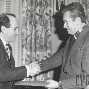dwóch mężczyzn zwróconych do siebie twarzami podaje sobie ręce