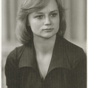 portret młodej kobiety  we włosach do ramion i w ciemnej sukience lub bluzce