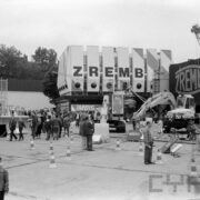 grupa ludzi przyglądająca się maszynom budowlanym wystawionym na placu