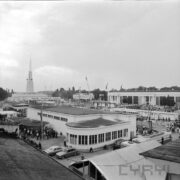 budynki wystawowe, między nimi spacerujący ludzie