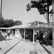 zadaszone stoisko z oponami, spacerujący ludzie