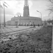 budynek targowy, zwany Iglicą, z lewej maszty z flagami