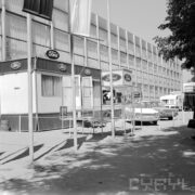 przeszklona hala wystawowa, przed nią samochody osobowe