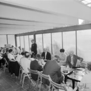 kobiety i mężczyźni siedzą przy zastawionych stolikach